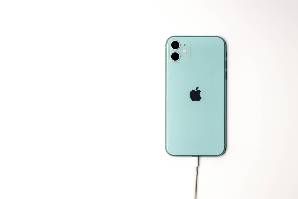 Green iPhone 11 charging with cable