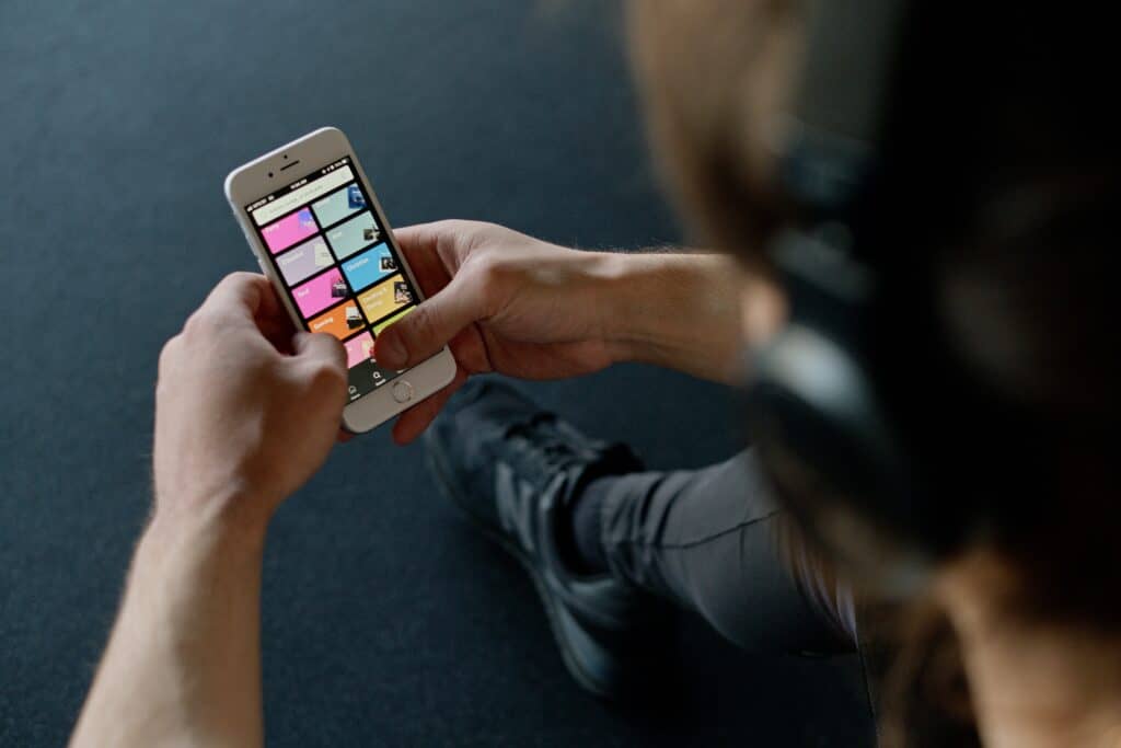 man with headphone browsing spotify on iphone