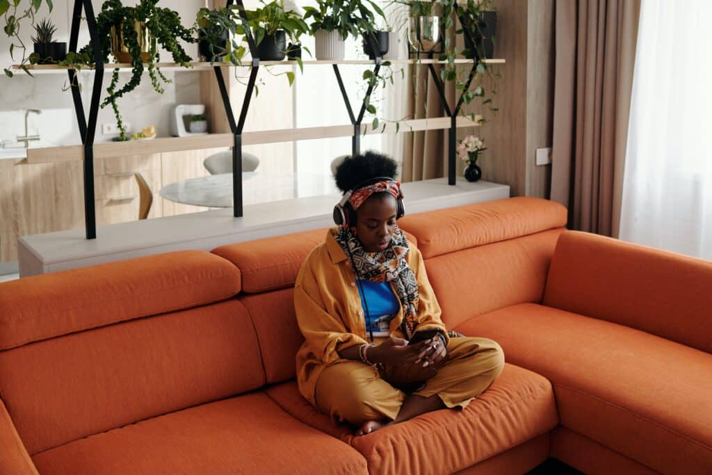 woman sitting on the sofa while listening to music