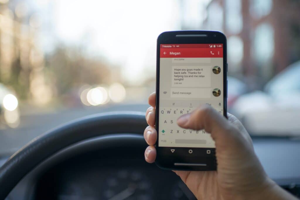 person texting on phone while in car